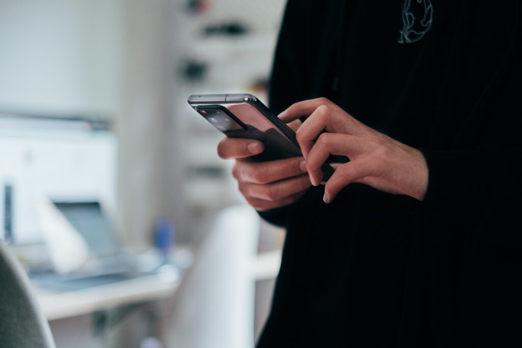 Mãos de uma pessoa branca segurando o melhor celular custo-benefício.